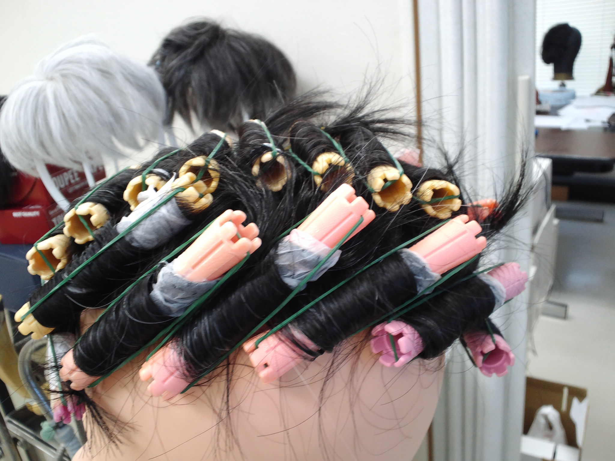 かつらにパーマロッドを巻いて形をつける作業。プロフィットLLC店内